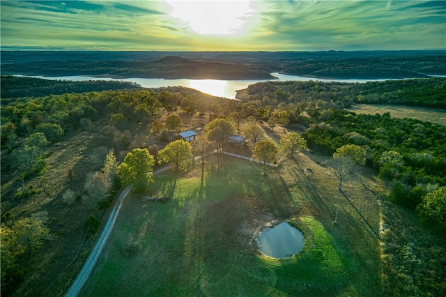 aerial view at dusk featuring a water view