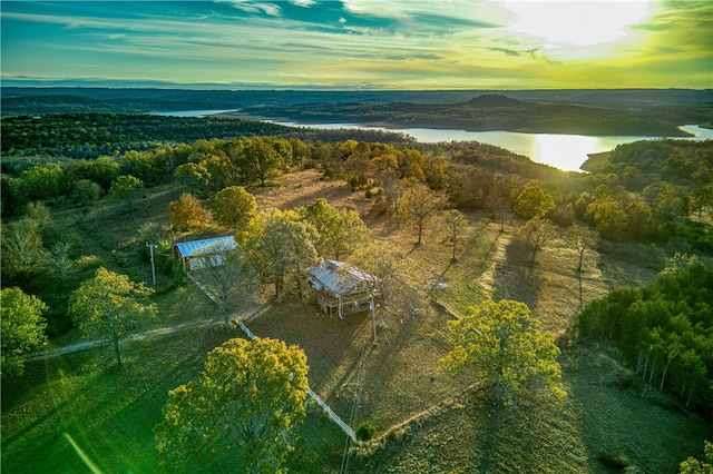 aerial view at dusk featuring a water view