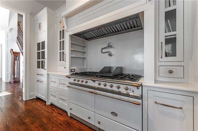 kitchen with dark wood-type flooring, white cabinetry, premium range hood, and stainless steel range