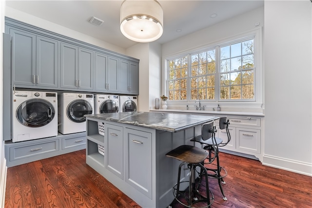 washroom featuring separate washer and dryer, dark wood-type flooring, cabinets, and sink