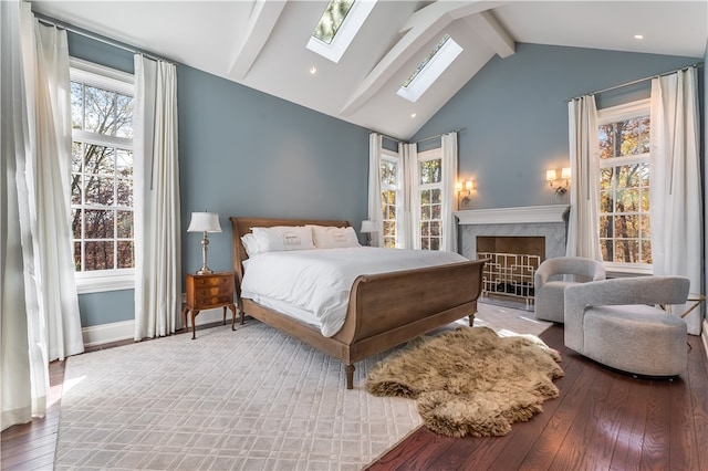 bedroom with wood-type flooring and vaulted ceiling with beams