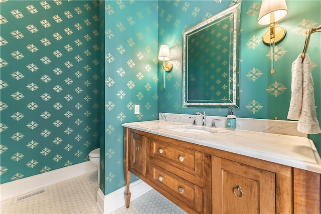 bathroom with tile patterned flooring, vanity, and toilet