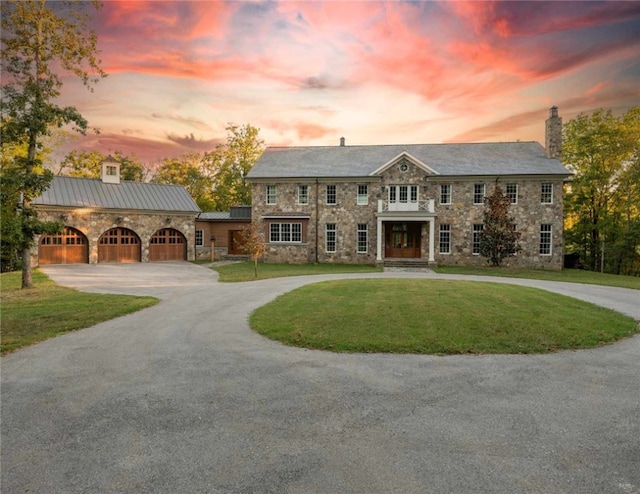 view of front of property featuring a garage and a lawn