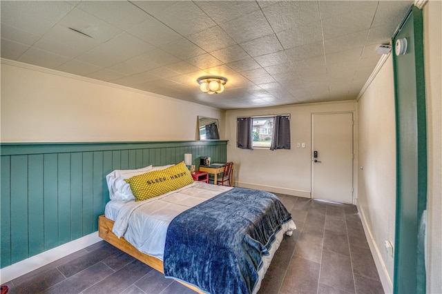 bedroom featuring wooden walls and ornamental molding