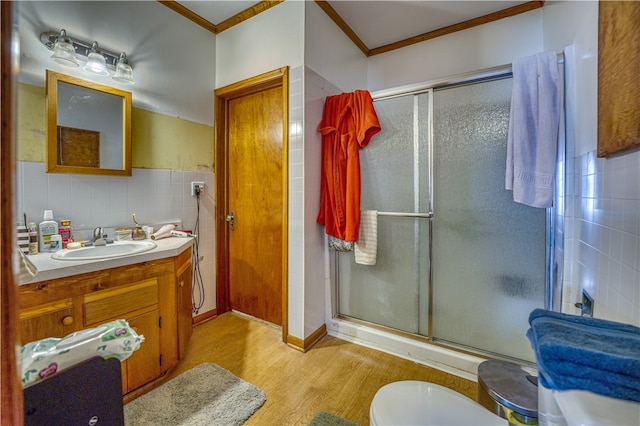 bathroom featuring walk in shower, wood-type flooring, ornamental molding, and vanity