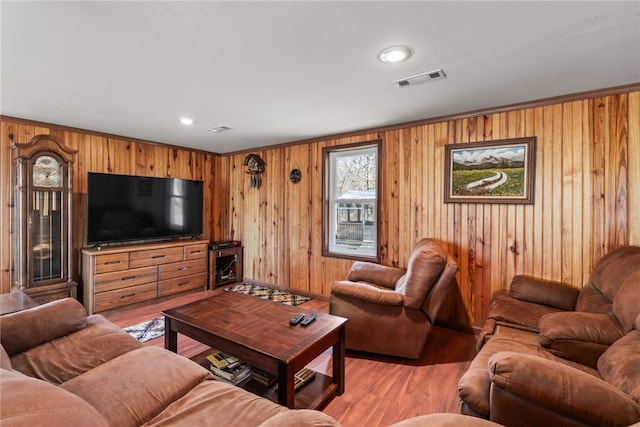 living room with hardwood / wood-style flooring and wooden walls