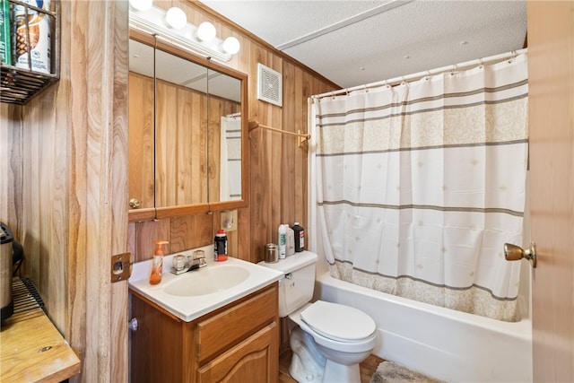 full bathroom with wood walls, shower / bath combination with curtain, a textured ceiling, toilet, and vanity