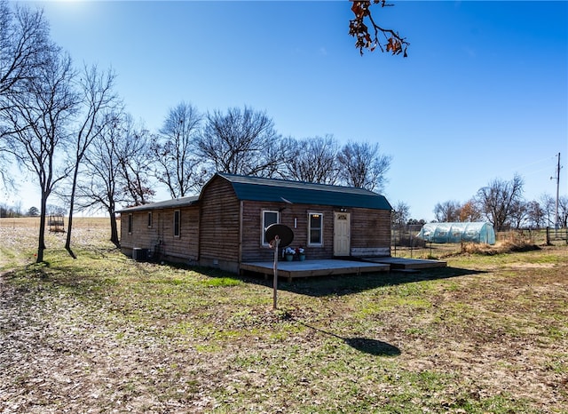 exterior space featuring a shed, a deck, and a lawn