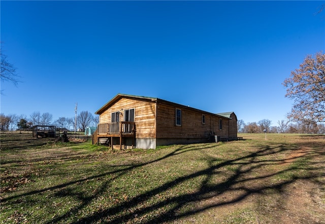 view of side of home featuring a yard and a deck