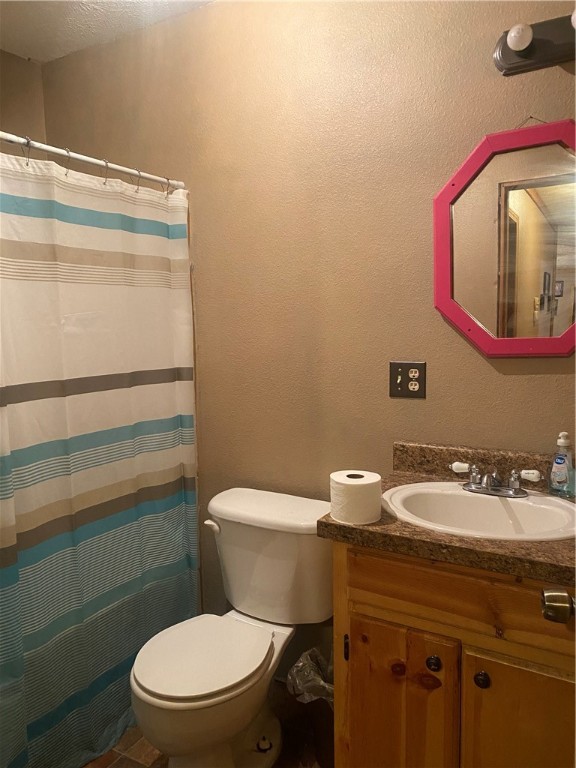 bathroom featuring a shower with shower curtain, vanity, and toilet