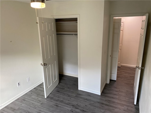 unfurnished bedroom featuring a closet and dark hardwood / wood-style floors