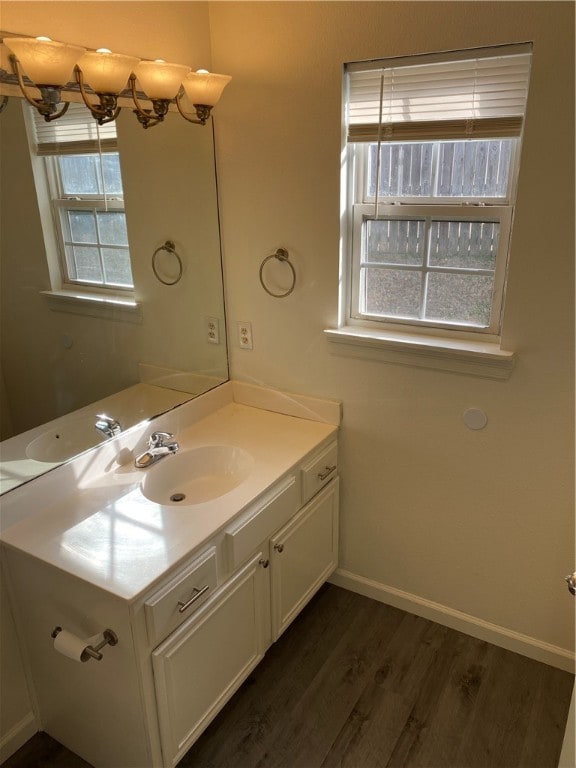 bathroom featuring a wealth of natural light, vanity, hardwood / wood-style flooring, and a chandelier