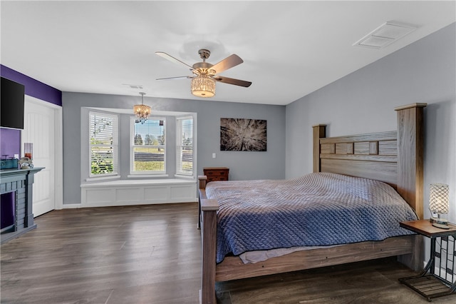 bedroom featuring ceiling fan, dark hardwood / wood-style flooring, and a fireplace