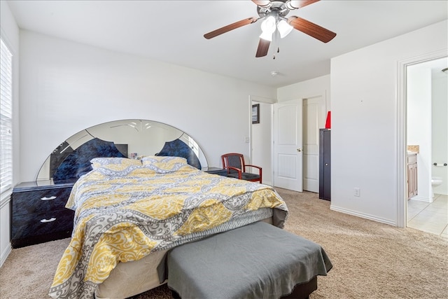 bedroom with ceiling fan, ensuite bathroom, light colored carpet, and multiple windows