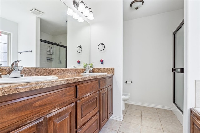 bathroom featuring vanity, a shower with shower door, tile patterned flooring, and toilet