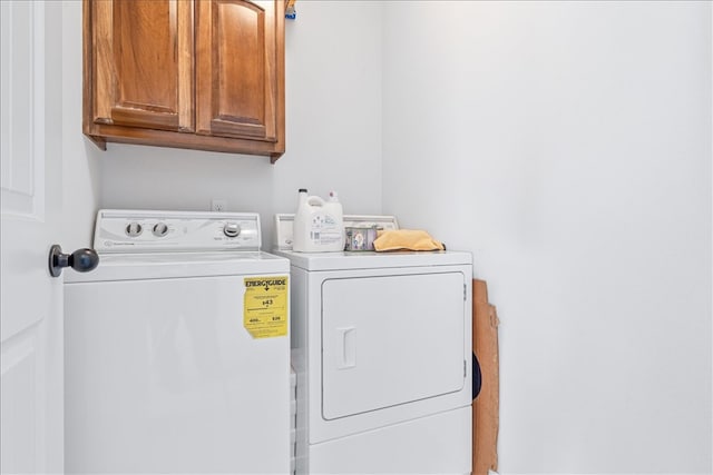 washroom featuring washing machine and dryer and cabinets