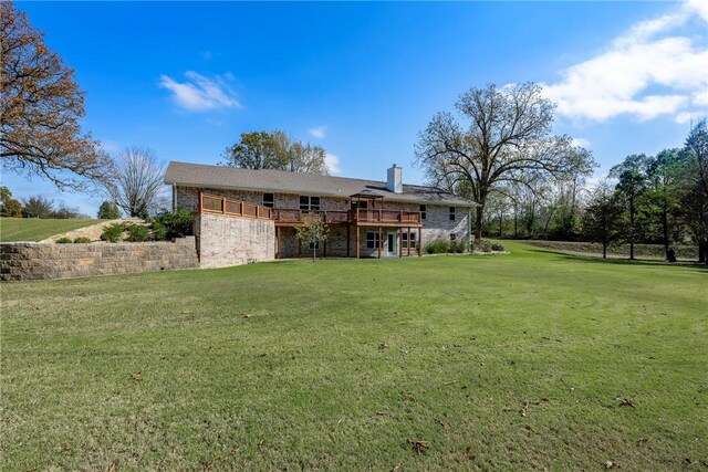 back of house with a deck and a lawn