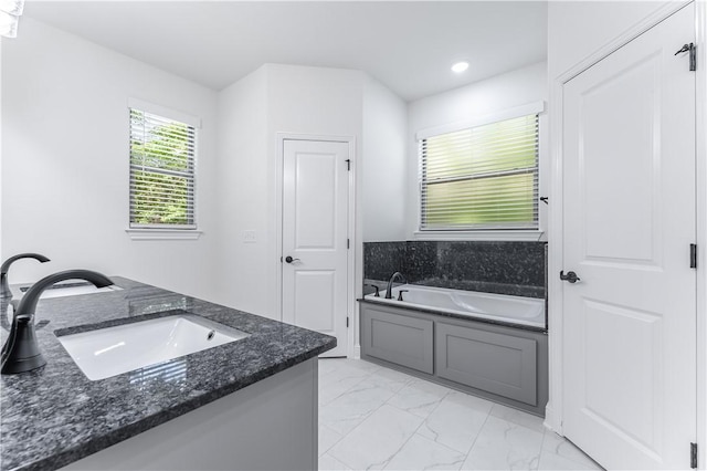 bathroom with a washtub and vanity