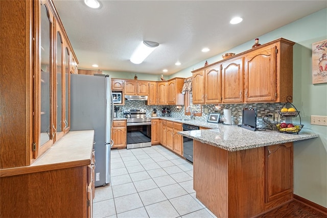 kitchen featuring sink, backsplash, kitchen peninsula, light tile patterned floors, and appliances with stainless steel finishes