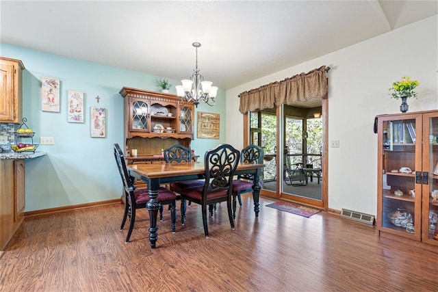 dining space featuring a chandelier and dark hardwood / wood-style flooring