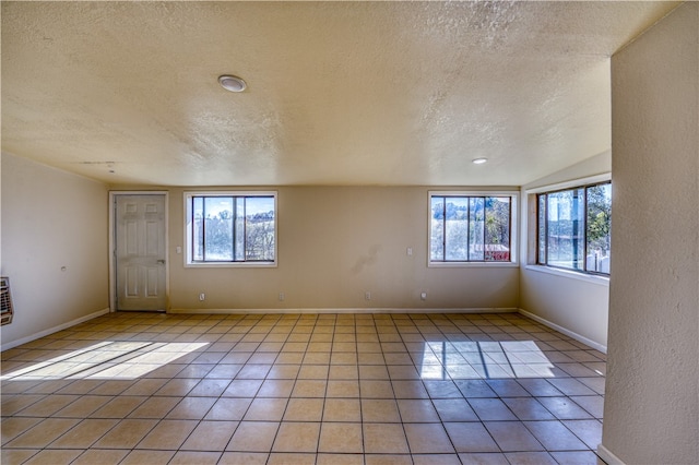 tiled spare room with a healthy amount of sunlight and a textured ceiling