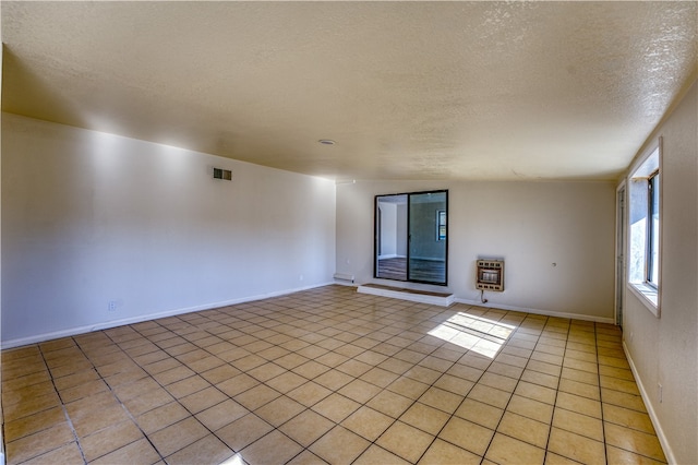 spare room featuring light tile patterned flooring, a textured ceiling, vaulted ceiling, and heating unit