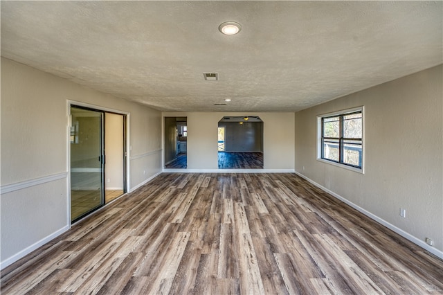 unfurnished living room with wood-type flooring and a textured ceiling