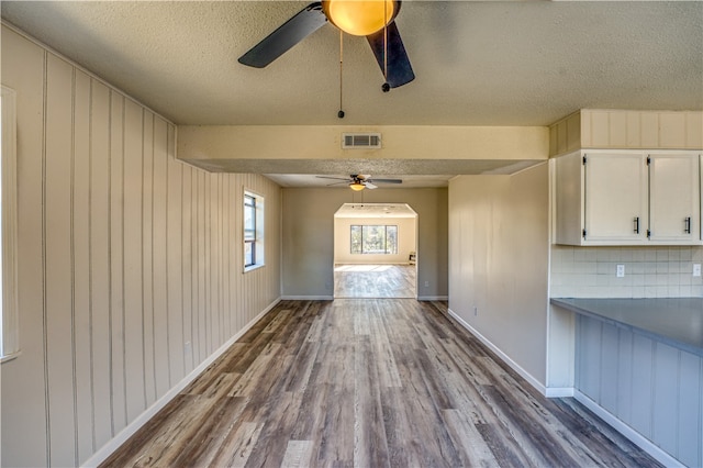 interior space featuring wood walls, wood-type flooring, and a textured ceiling