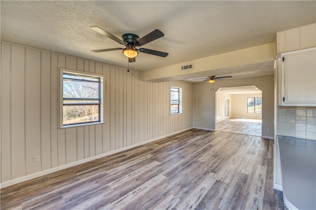 unfurnished room with light hardwood / wood-style floors, a textured ceiling, and ceiling fan