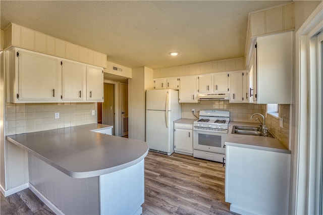 kitchen featuring white cabinets, kitchen peninsula, light hardwood / wood-style flooring, and white appliances