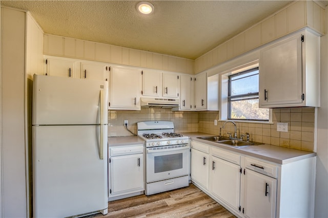 kitchen featuring light hardwood / wood-style floors, white cabinetry, sink, a textured ceiling, and white appliances