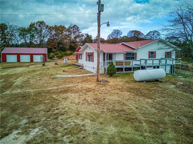 view of front facade featuring a garage, a front yard, and an outdoor structure