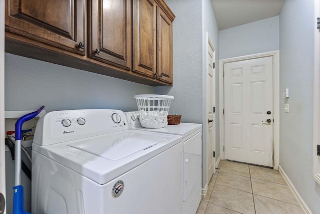 laundry area featuring cabinet space, independent washer and dryer, baseboards, and light tile patterned floors