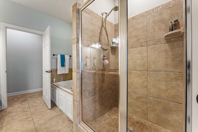 bathroom featuring a stall shower, a garden tub, and tile patterned floors