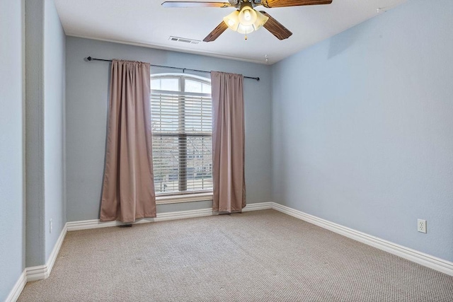 carpeted empty room featuring visible vents, baseboards, and ceiling fan