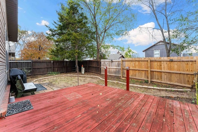 wooden terrace with a fenced backyard