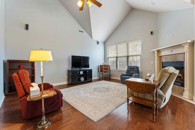 living room featuring ceiling fan, high vaulted ceiling, a fireplace, wood finished floors, and visible vents