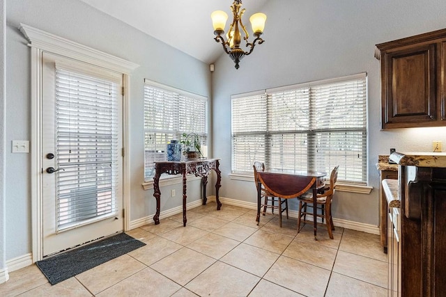 dining room with light tile patterned floors, plenty of natural light, and vaulted ceiling