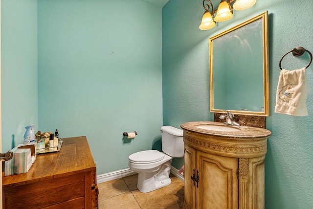 bathroom with toilet, tile patterned flooring, baseboards, and vanity