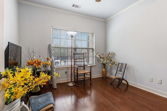 living area featuring baseboards, crown molding, visible vents, and wood finished floors