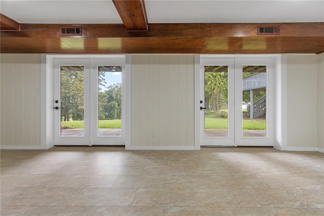 doorway to outside with plenty of natural light and beamed ceiling