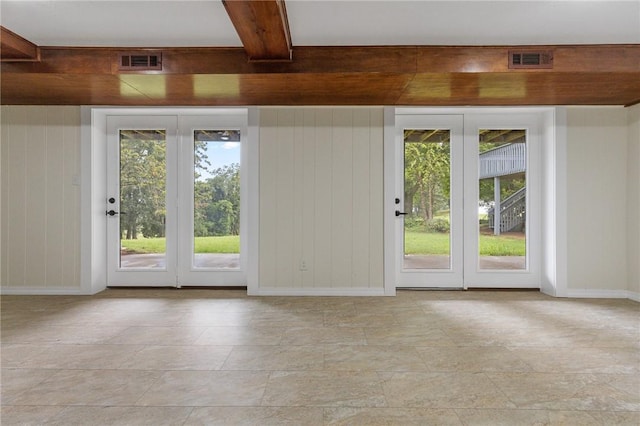 doorway featuring stone finish floor, visible vents, and baseboards