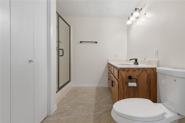 full bathroom featuring baseboards, a shower stall, toilet, and vanity