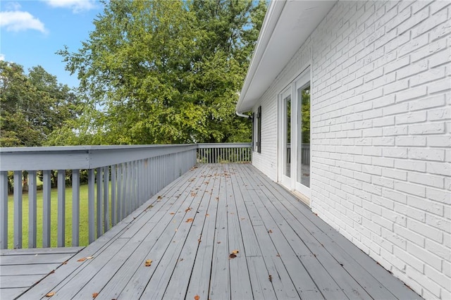 wooden deck featuring a lawn