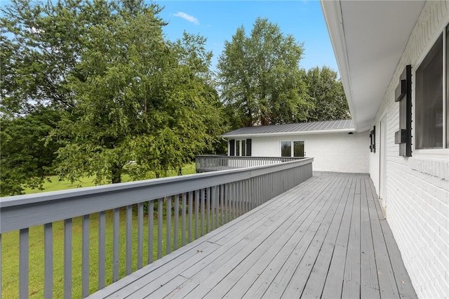 wooden terrace featuring a yard