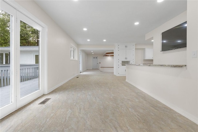 unfurnished living room featuring recessed lighting, visible vents, baseboards, and a healthy amount of sunlight
