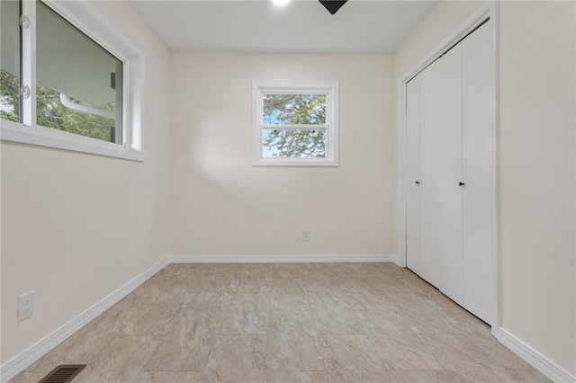 unfurnished bedroom featuring a closet, visible vents, and baseboards