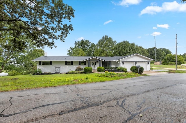 single story home featuring a garage and a front yard