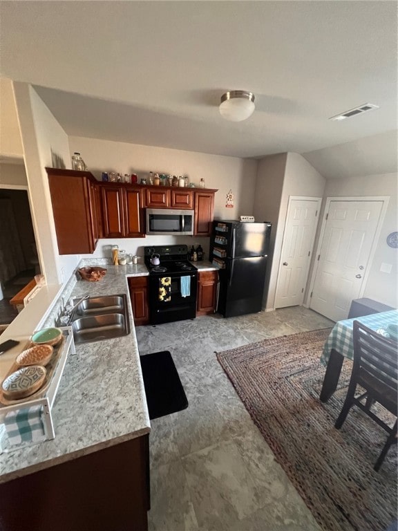 kitchen featuring black appliances, sink, and lofted ceiling