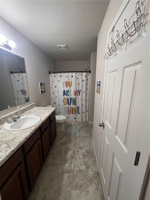 bathroom featuring toilet, vanity, a textured ceiling, and a shower with shower curtain